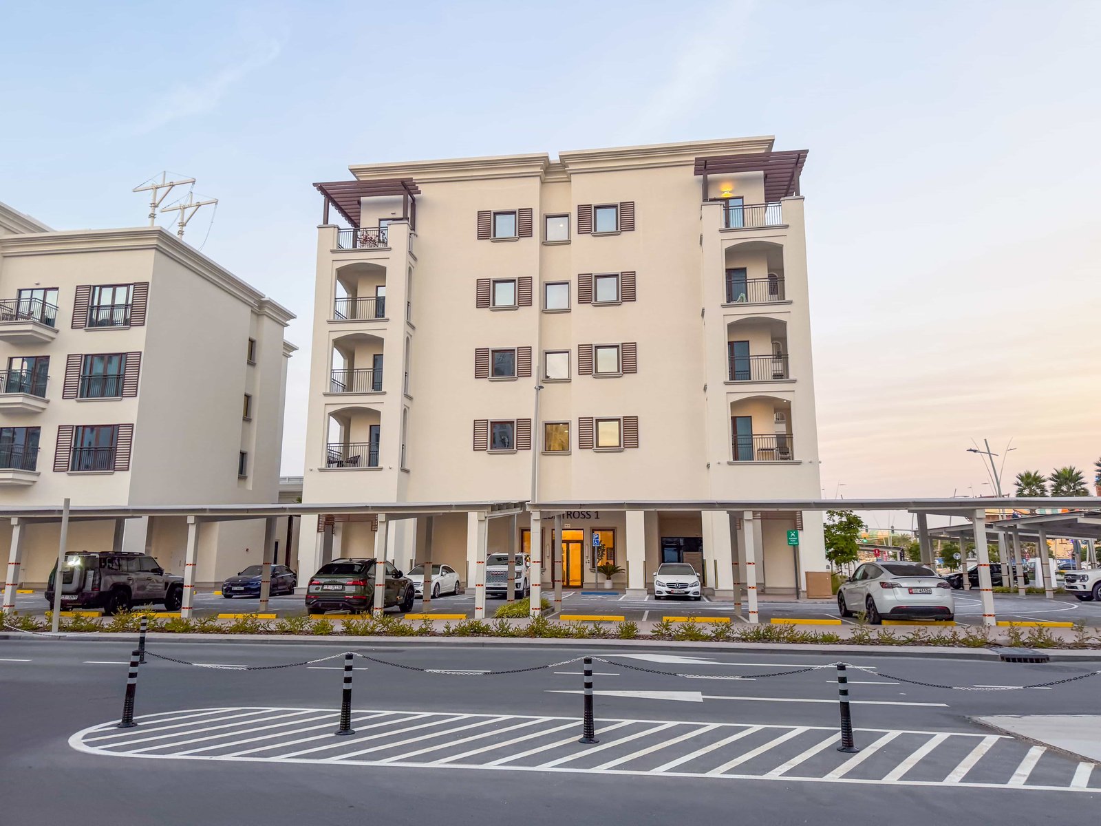 Evening shot of Yas Golf Collection highlighting illuminated podium areas, contemporary architecture, and surrounding golf course greenery.